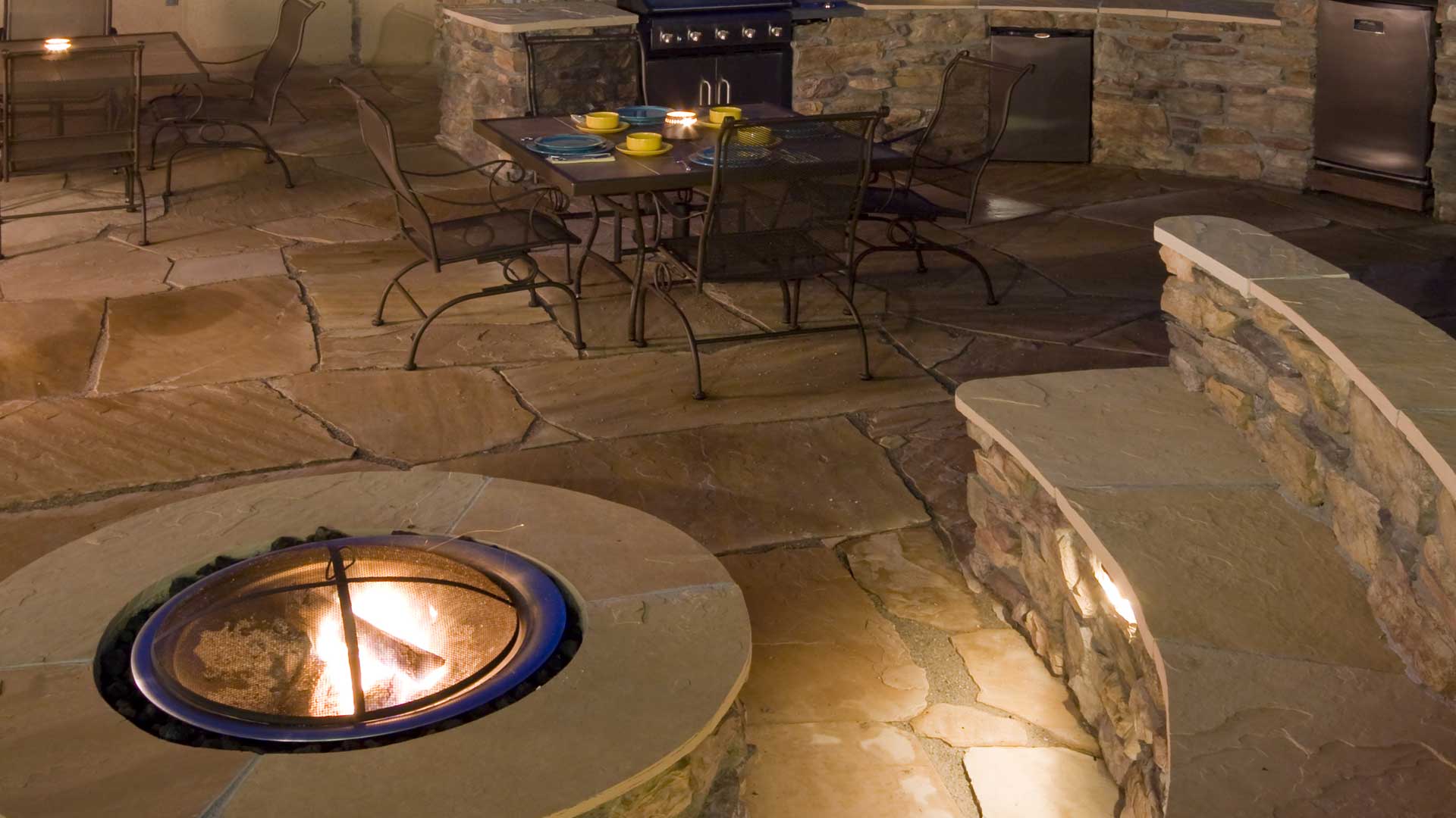 New fire pit, patio, and seating wall in the backyard of a home in Broomfield, CO